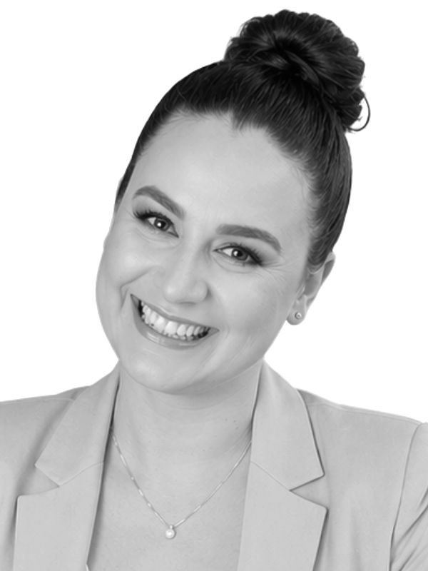Black-and-white portrait: Cristina Ionescu-Taifas in a blazer, smiling.